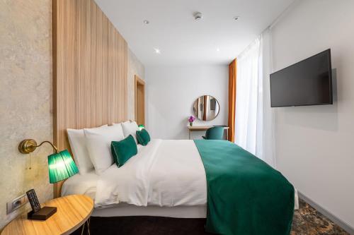 a hotel room with a bed and a television at Tomis Garden Aparthotel Bucuresti in Bucharest