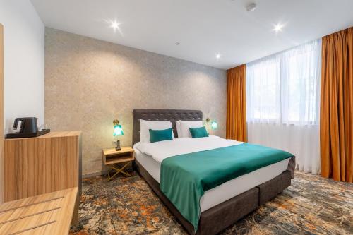 a bedroom with a large bed and a television at Tomis Garden Aparthotel Bucuresti in Bucharest