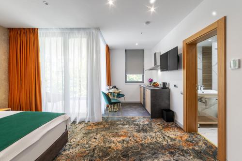 a hotel room with a bed and a bathroom at Tomis Garden Aparthotel Bucuresti in Bucharest