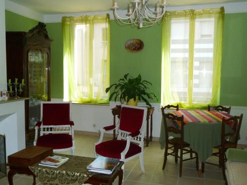 - un salon avec des murs verts, une table et des chaises dans l'établissement Le Clos Tolosan, à Ramonville-Saint-Agne