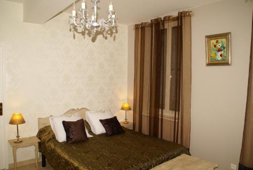 a bedroom with a bed and a chandelier at Le Clos Tolosan in Ramonville-Saint-Agne