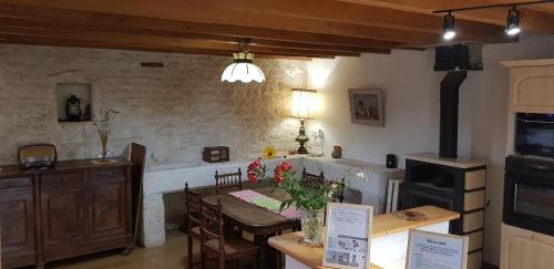 - une cuisine et une salle à manger avec une table fleurie dans l'établissement Charmante maison de campagne, à Nalliers