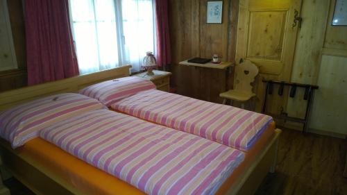 a bedroom with two beds with striped sheets at Hotel-Restaurant Drei Tannen in Niederwald