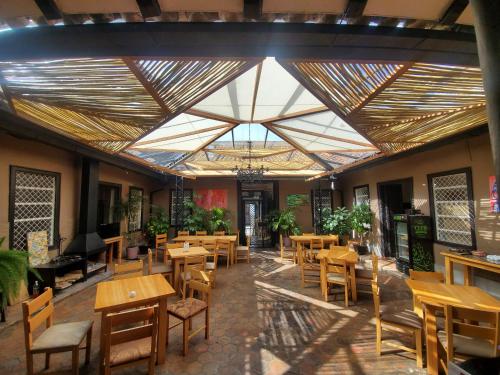 a restaurant with wooden tables and chairs and a large ceiling at Hotel Casa Merced in Cuenca