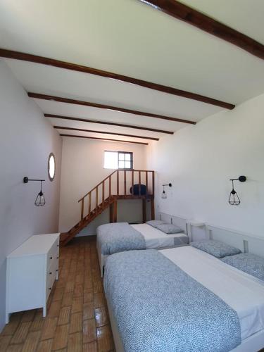 a room with three beds and a staircase at Casa Baptista in Monchique