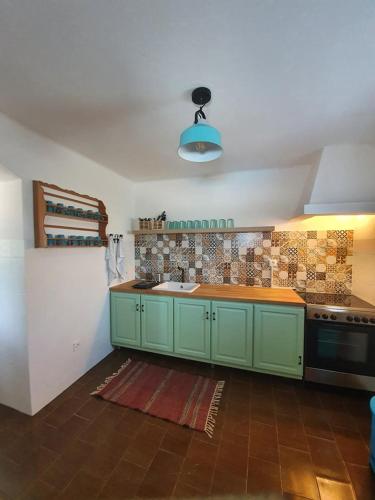 a kitchen with green cabinets and a stove at Casa Baptista in Monchique