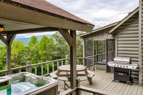 a deck with a hot tub and a grill at Buck Moon Cabin in Blairsville