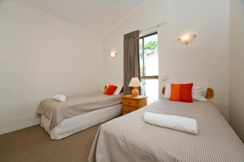 a bedroom with two beds and a window at Caralina Court in Noosa Heads