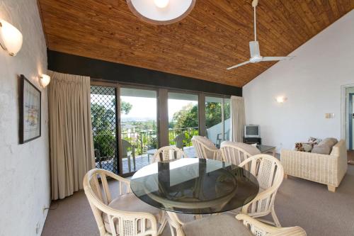 a dining room with a glass table and chairs at Caralina Court in Noosa Heads