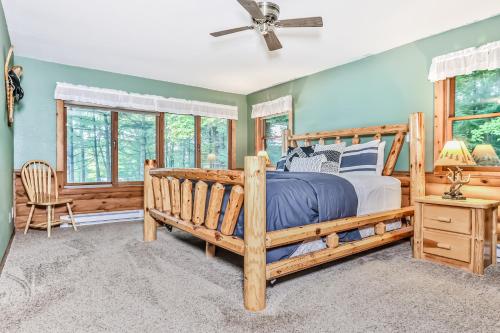 um quarto com uma cama de madeira e uma ventoinha de tecto em Paradise Pines em Lac du Flambeau