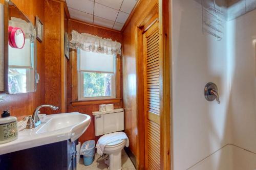 a bathroom with a white toilet and a sink at Beach Bungalow in Seabrook