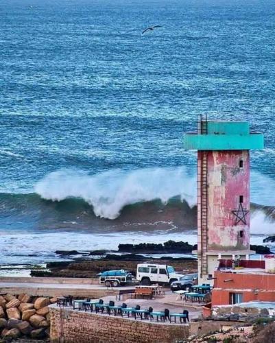 a lighthouse on the beach next to the ocean at Brothers House 1 in Imsouane