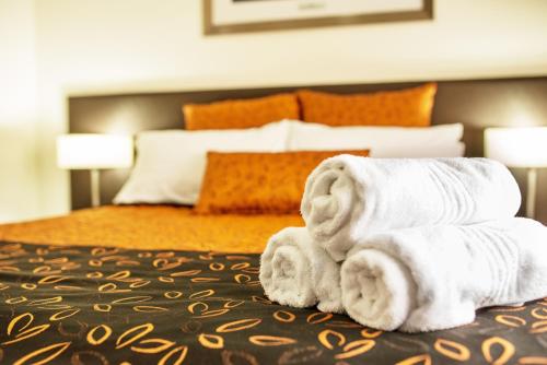 a pile of towels sitting on top of a bed at Comfort Inn & Suites Augusta Westside in Port Augusta