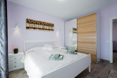 Un dormitorio con una cama blanca y una pintura en la pared en Palm Mar de LUX A26, en Palm-mar