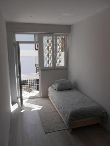 Schlafzimmer mit einem Bett und einem Fenster in der Unterkunft OPO Downtown - cozy apartment @Oporto city center in Porto