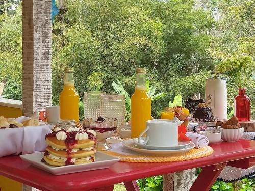 a table with pancakes and orange juice and drinks at Pousada Polessas in Visconde De Maua