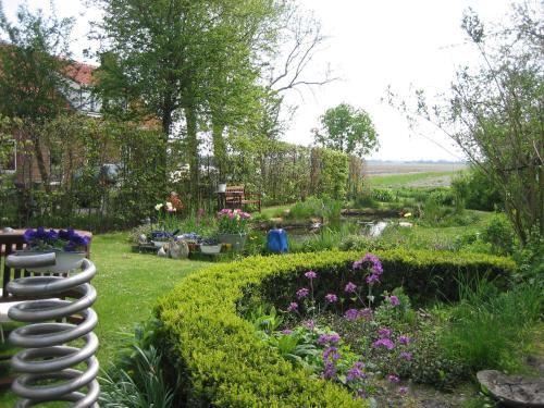 a garden with a sculpture of a butterfly at Finisterre in Saaxumhuizen