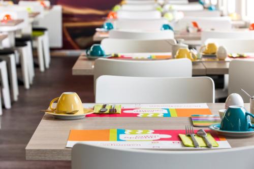 a row of tables and chairs in a dining room at ibis Styles Arnsberg - Neheim in Arnsberg