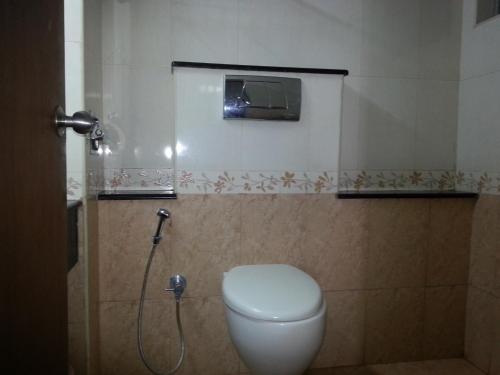 y baño con aseo blanco y ducha. en Lotus Bay View Hotel en Pondicherry
