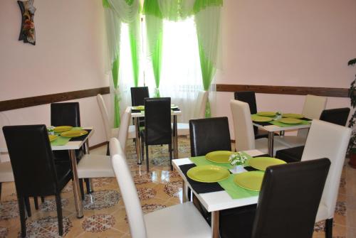 a dining room with tables and chairs with green plates at Pensiunea Queen Mary in Sînpetru