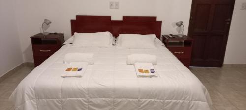 a large white bed with two towels on it at Departamento temporario con cochera in Resistencia