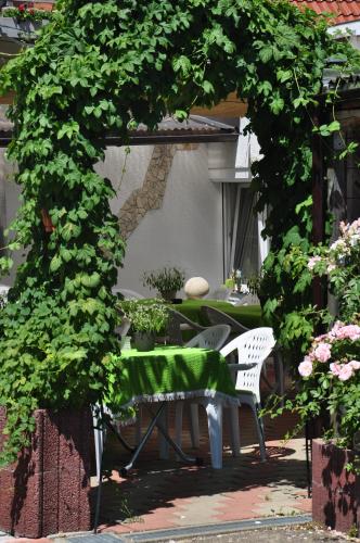 a table and chairs under an arch with plants at Gasthof Liederhalle in Aalen