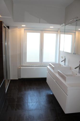 łazienka z dwiema umywalkami i dwoma oknami w obiekcie Golden Tulip w Ostendzie