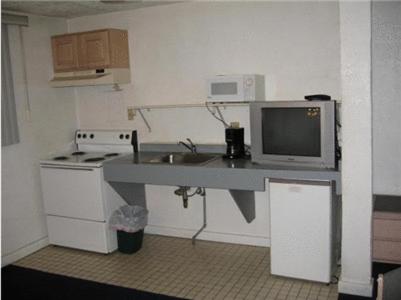 a small kitchen with a sink and a microwave at Hub Motel in Redmond