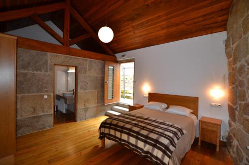 a bedroom with a large bed and a bathroom at Casa de Santa Cristina in Alpendurada
