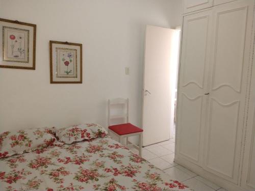 1 dormitorio con 1 cama con colcha de flores en Quarto e sala silencioso em Copacabana, en Río de Janeiro