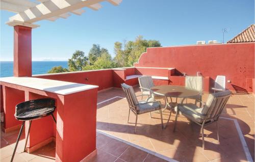 a patio with a table and chairs on a roof at 2 Bedroom Cozy Apartment In Estepona in Estepona