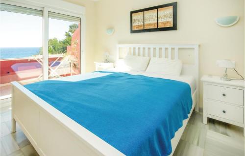 ein Schlafzimmer mit einem Bett mit einer blauen Decke und einem Fenster in der Unterkunft 2 Bedroom Cozy Apartment In Estepona in Estepona
