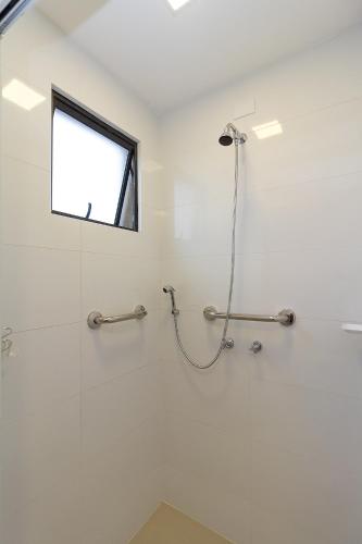 a bathroom with a shower with a window at Pleione Flats in Curitiba