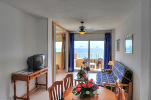 a living room with a dining room table with a view of the ocean at Apartamentos La Mirage in La Manga del Mar Menor
