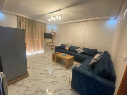 a living room with a blue couch and a table at LA CASA DEL SOL IMSOUANE in Imsouane