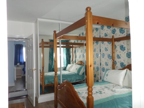 ein Schlafzimmer mit einem Himmelbett in einem Zimmer in der Unterkunft Sunrise Cottage in Lowestoft
