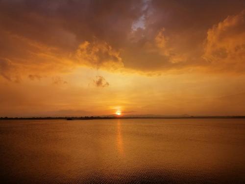 a sunset over a large body of water at Geethani Tourist Home Polonnaruwa in Polonnaruwa