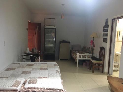 a bedroom with two beds and a table and a couch at SUITE - CIDADE das CACHOEIRAS in Santa Rita de Jacutinga
