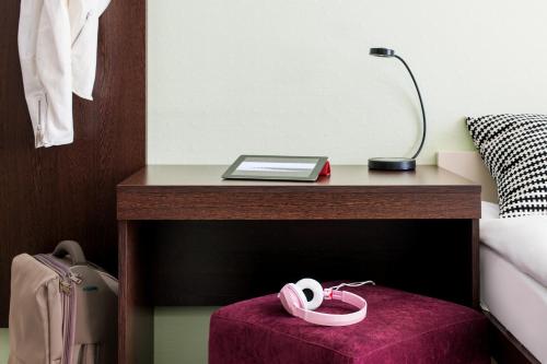 a table with a pair of headphones on a purple ottoman at SleepinRoomz Boutique Hotel in Dortmund