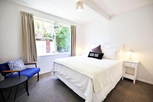 een witte slaapkamer met een bed en een raam bij Spa pool Treat in Taupo