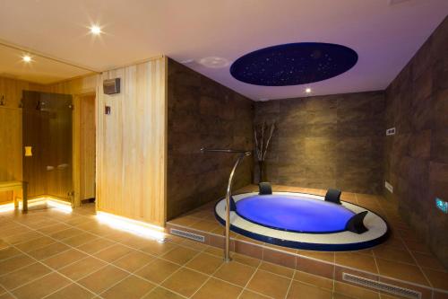 a bathroom with a large blue tub in a room at Penzión Kohútik in Oravská Lesná