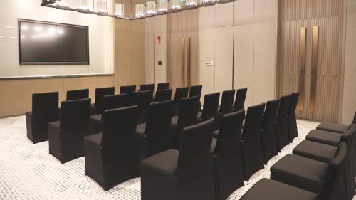 a conference room with black chairs and a screen at Holiday Inn Xi'an Chanba by IHG-Near Xi'an International Convention Exhibition Center and Shopping mall and The Romantic show of Xi'an-Free Luggage Storage-English Service in Xi'an