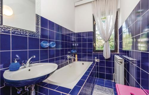 a blue tiled bathroom with a sink and a tub at Amazing Apartment In Rijeka With House A Panoramic View in Rijeka
