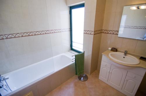 a bathroom with a bath tub and a sink at Dalia in Quarteira