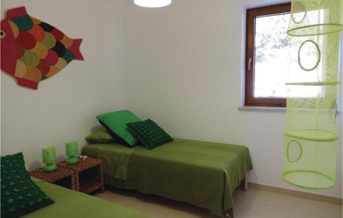 a bedroom with a green bed and a window at Lovely Apartment In Labin With Wifi in Labin