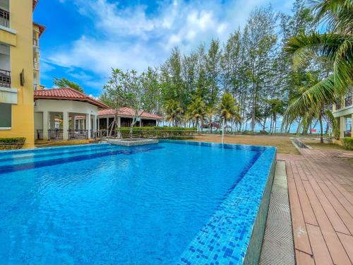 a large blue swimming pool in front of a building at Tiara Desaru Seaview Residence in Desaru