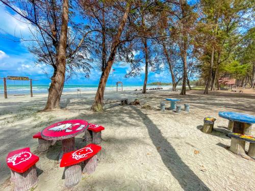 a group of picnic tables in the sand on the beach at Tiara Desaru Seaview Residence in Desaru