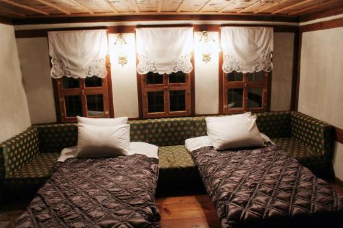 two beds on a couch in a room with windows at Gulevi Safranbolu in Safranbolu