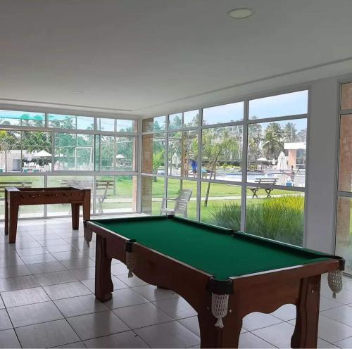 a pool table in a room with windows at Muro Alto condomínio clube in Porto De Galinhas