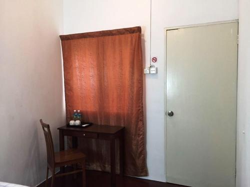 a room with a table and a door with a table and a chair at Travellers Diary Guesthouse in Melaka